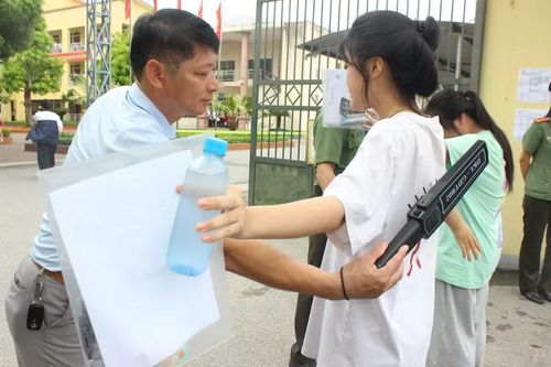 Lực lượng công an phối hợp cán bộ làm nhiệm vụ sử dụng máy quét an ninh cầm tay kiểm tra thí sinh trước khi vào khu vực thi