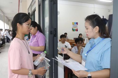 Cán bộ coi thi đối chiếu thông tin của thí sinh trước khi vào phòng thi.