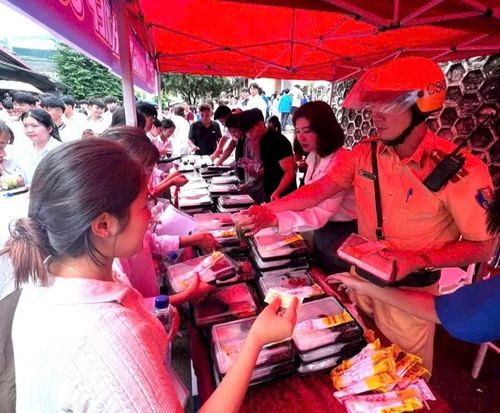 Lực lượng CSGT khu vực Sông Mã, tỉnh Sơn La hỗ trợ chị Luyến phát cơm cho học sinh.