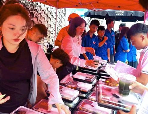 Hàng trăm suất cơm miễn phí được chị Luyến (người mặc áo trắng ở giữa) hỗ trợ cho các thí sinh.