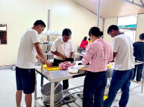 Ngay từ sáng sớm, nhiều phụ huynh đã có mặt tại Trung tâm để cùng thầy cô chuẩn bị nguyên liệu, nấu ăn và chia suất cơm cho học sinh.