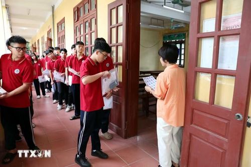 Cán bộ coi thi trường Trung học phổ thông Tân Trào, phường Minh Xuân (Tuyên Quang) kiểm tra, đối chiếu thông tin thí sinh trước khi vào phòng thi. (Ảnh: Quang Cường/TTXVN)