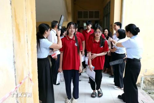 Cán bộ coi thi trường Trung học Phổ thông Tân Trào, phường Minh Xuân (Tuyên Quang) kiểm tra thí sinh trước khi vào phòng thi. (Ảnh: Quang Cường/TTXVN)