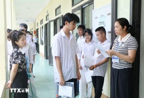 Giám thị tại điểm thi trường THPT Tam Nông (xã Tam Nông, tỉnh Phú Thọ) kiểm tra thông tin thí sinh trước khi vào phòng thi. (Ảnh: Thu Hương/TTXVN)