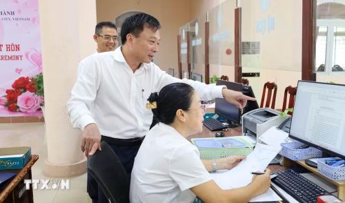 Chủ tịch UBND phường Chơn Thành Nguyễn Anh Tài kiểm tra tại Trung tâm phục vụ hành chính công. (Ảnh: Đậu Tất Thành/TTXVN)