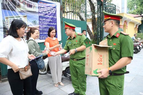 Ngoài lực lượng sinh viên tình nguyện, các chiến sĩ công an cũng tham gia phát nước uống miễn phí cho thí sinh và phụ huynh tại điểm thi ở Hà Nội