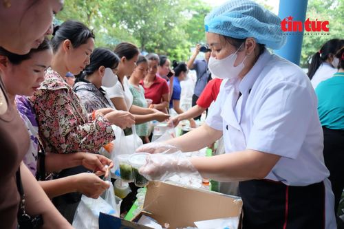 Hàng dài phụ huynh xếp hàng nhận cơm trưa miễn phí.