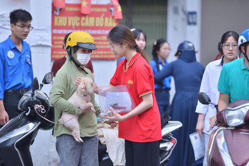 Chị Trần Thị Thu Trang đưa con gái Lê Trần Ngọc Khánh đến điểm thi, đồng thời mang theo thú cưng tên Cam Cam.
