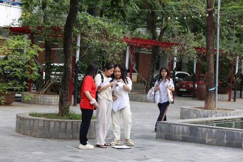 Các sĩ tử nán lại sân trường để đối chiếu kết quả. Ảnh: Vân Đức