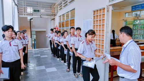 Cán bộ coi thi tại điểm thi Trường THPT Thoại Ngọc Hầu gọi thí sinh vào phòng thi. Ảnh: THANH NHÃ