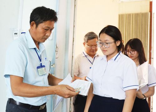 Cán bộ coi thi tại điểm thi Trường THPT chuyên Huỳnh Mẫn Đạt, phường Rạch Giá gọi tên thí sinh vào phòng thi môn toán. Ảnh: BÍCH TUYỀN
