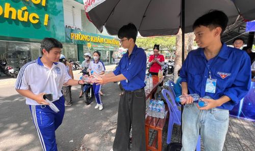 Thí sinh được Đội Tình nguyện tiếp nước uống trước khi vào phòng thi. Ảnh: NGUYỄN HƯNG