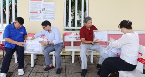Cán bộ, giáo viên Trường THPT Phó Cơ Điều, phường Rạch Giá sắp xếp vật dụng cần thiết cho học sinh của trường. Ảnh: BÍCH TUYỀN