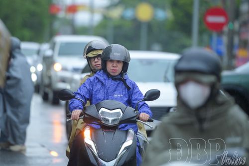 Tuy trời đổ mưa nhưng nhiều phụ huynh đưa con đến điểm thi từ sớm, động viên các em trước giờ làm bài.