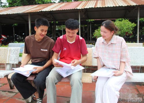Em Lò Văn Quyền (ngồi giữa) trao đổi về đề thi Toán với các thí sinh.