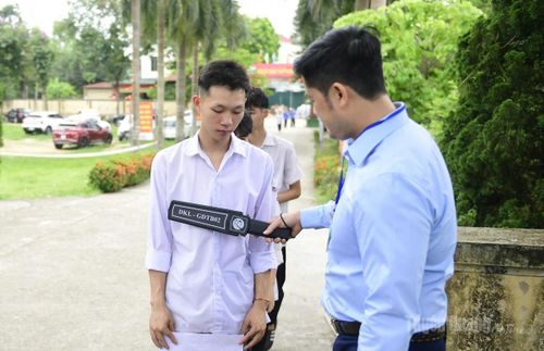 Cán bộ tại điểm thi Trường THPT Xuân Huy kiểm tra an ninh đối với các thí sinh dự thi chiều nay. Ảnh Quốc Việt