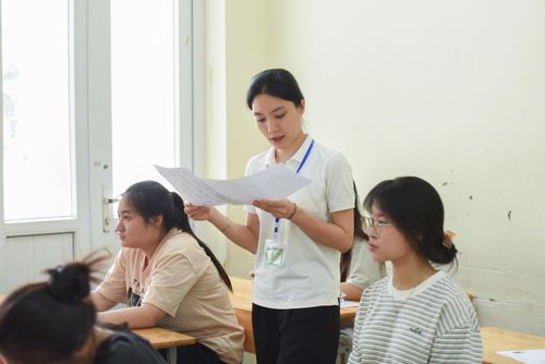 Giám thị đối chiếu thông tin thí sinh tại điểm thi trường THCS Mễ Trì (phường Từ Liêm). Ảnh: Xuân Quý