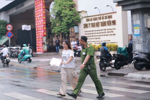 Cán bộ Công an dẫn thí sinh qua đường đến điểm thi an toàn.