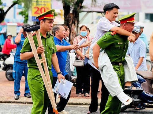 Cán bộ Công an trực tiếp hỗ trợ em Lê Đăng Khoa, đến phòng thi tại trường THPT Hồ Thị Kỷ an toàn.