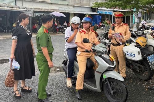 Cán bộ Phòng CSGT hỗ trợ em Ngô Diễm My đến điểm thi Trường THPT Nguyễn Việt Khái đúng giờ, an toàn.