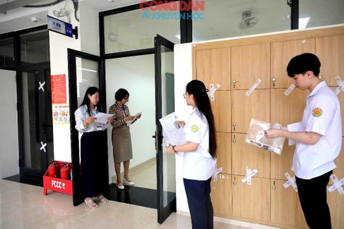 Cán bộ coi thi gọi tên thí sinh làm thủ tục vào phòng thi theo qui định. Ảnh: Quốc Hồng