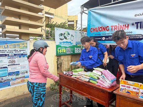 Phụ huynh nhận áo mưa từ đội tiếp sức mùa thi.