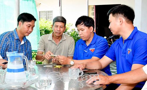Thành viên tổ công nghệ số cộng đồng hướng dẫn người dân, hộ kinh doanh cài đặt và sử dụng các ứng dụng số.