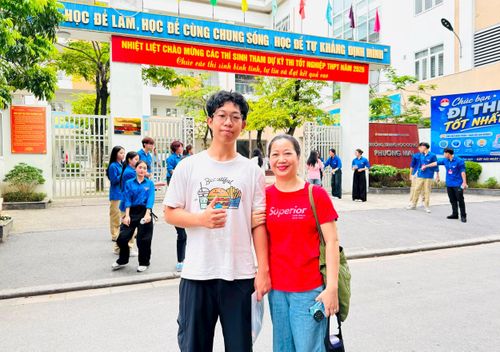 Thí sinh Nguyễn Minh Tuấn cùng mẹ có mặt từ sớm tại điểm thi Trường THCS Phương Mai. Ảnh: PV