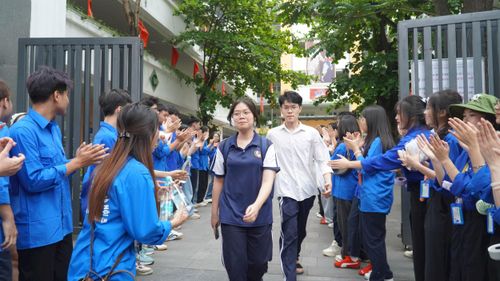 Sĩ tử tại điểm thi Trường THCS Ngô Sỹ Liên rời phòng thi trong vòng tay động viên và cổ vũ của các tình nguyện viên. Ảnh: PV