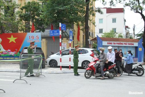 Công an phường phối hợp với các đơn vị liên quan phân luồng hỗ trợ thí sinh và phụ huynh tại điểm thi. Ảnh: Hoàng Vũ