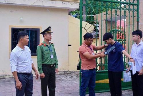 Thí sinh được kiểm tra bằng máy quét cầm tay trước khi hoàn tất thủ tục vào phòng thi. Ảnh:CAHT.