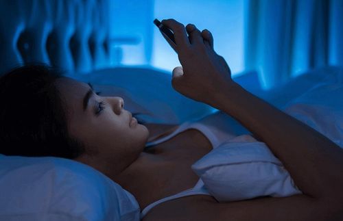Việc lướt điện thoại trên giường trước khi ngủ có thể làm tăng nguy cơ mắc bệnh đục thủy tinh thể. Ảnh: Shutterstock.
