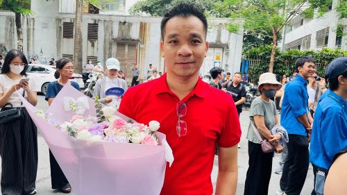 Người cha ôm hoa chờ đón con ở cổng trường