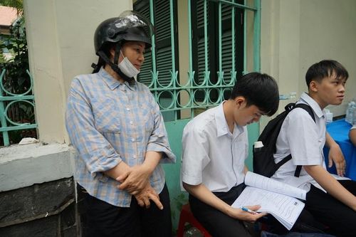 Chị Phạm Thị Ngân chăm sóc và động viên con trai Trần Đức Hậu trong lúc em tranh thủ ôn lại kiến thức trước giờ thi môn toán.