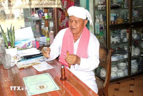 Ông Thông Long say sưa kể về cấu tạo của chiếc kèn saranai. (Ảnh: Hồng Hiếu/TTXVN)