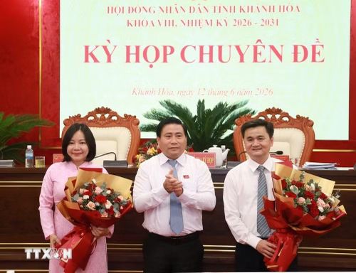 Ông Lâm Đông, Phó Bí thư Tỉnh ủy, Chủ tịch Hội đồng Nhân dân tỉnh Khánh Hòa tặng hoa chúc mừng 2 thành viên Ủy ban Nhân dân tỉnh. (Ảnh: Xuân Triệu/TTXVN)