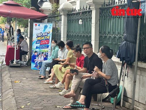 Các phụ huynh ở điểm thi Trường THPT Yên Hòa đã chọn vị trí ổn định để chờ con trong buổi sáng.