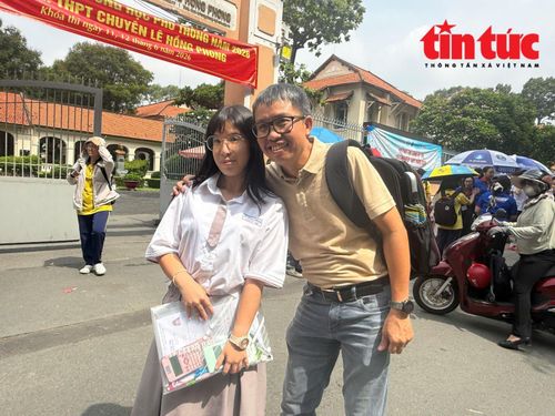 Bố tranh thủ chụp ảnh kỷ niệm cùng con ở cổng điểm thi.