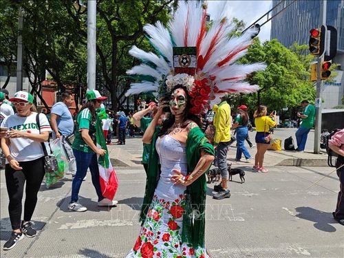 Một phụ nữ hóa trang với trang phục mang màu sắc quốc kỳ Mexico trên đại lộ Paseo de la Reforma trong ngày khai mạc World Cup 2026. Ảnh: Phương Lan/PV TTXVN tại Mexico