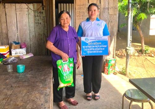 Phụ nữ Trà My thực hiện mô hình “Hũ gạo tình thương - San sẻ yêu thương” tặng gạo cho người già neo đơn. Ảnh: ĐVCC