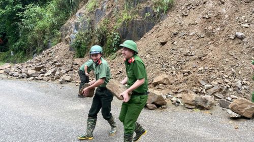 Cán bộ, chiến sĩ Công an xã Khao Mang thu dọn đá lăn, đảm bảo an toàn cho người và phương tiện tham gia giao thông.