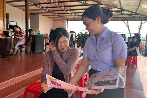 Chị Tô Thị Tuân, thôn Buôn Choáh (bên trái) được cán bộ hướng dẫn tìm hiểu các dịch vụ công trực tuyến và thủ tục hành chính tại cơ sở