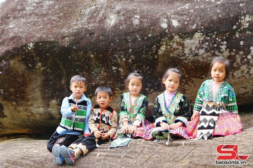 Các em nhỏ vui đùa bên bãi đá khắc cổ.