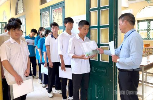 Cán bộ coi thi tại điểm thi trường THPT Ỷ La kiểm tra, đối chiếu thông tin thí sinh trước khi vào phòng thi Ảnh: Thúy Nga