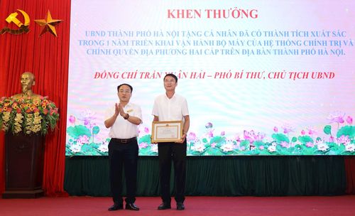 Bí thư Đảng ủy, Chủ tịch HĐND xã Phúc Sơn Phan Văn Sự trao Bằng khen của UBND thành phố tặng Chủ tịch UBND xã Phúc Sơn Trần Xuân Hải. Ảnh: Kim Nhuệ