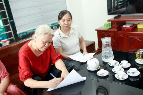 Bà Nguyễn Thị Lan ký nhất trí với phương án sắp xếp 4 thôn và đặt tên là thôn Bình Minh. Ảnh: Hồng Nhung