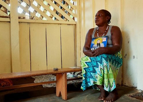 Bà Bertha Aleko ôm chặt bức ảnh của con trai quá cố, Mục sư Paluku Makundi Denis. Ảnh: Reuters.