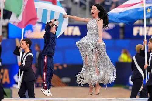 Katy Perry mang tới một trong những khoảnh khắc nổi bật nhất khi biểu diễn cùng Tius Luka. Nữ ca sĩ diện váy bạc lấp lánh, bước ra giữa đoàn cầm quốc kỳ của các đội tuyển dự World Cup 2026.