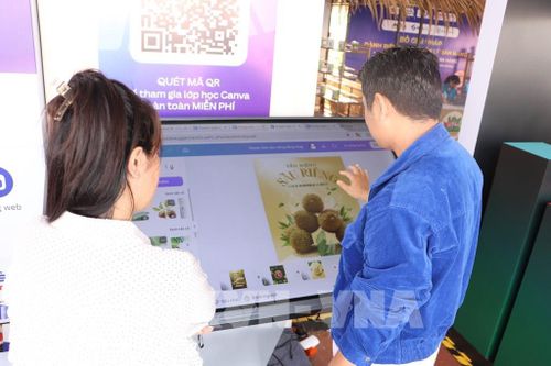 Tiểu thương tìm hiểu cách tạo clip và poster quảng bá sản phẩm lên sàn thương mại điện tử. Ảnh: Hồng Nhung - TTXVN