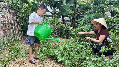 Bé Nguyễn Phạm Quang Anh (phường Đông Tiến) được mẹ hướng dẫn chăm sóc cây trong dịp nghỉ hè.